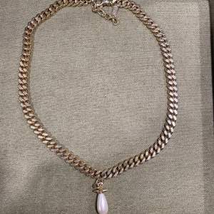 Smycke från Maria Nilsdotter. Köpt i år använd 5 gånger.   The Chunky Chain Drop Pearl Necklace is hand made in gold-plated silver with one drop shaped glass pearl and spike detailing. The necklace is adjustable between 40 to 45cm