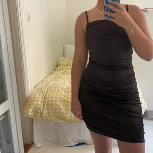 Brun Klänning - Supersmickrande brun klänning i glansigt stretchigt material. 