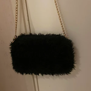 Axel väska i svart 🖤 - Axelväska med fluffig tyg samt fina guld detaljer. Passar perfekt till sena sommar kvällar 💕