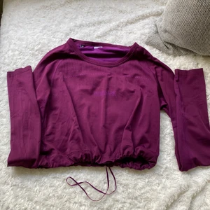 Gymshark  - Gymshark croppad tröja med snörning i midjan, färg lila, kommer inte ihåg kollektionen. I storlek S, använd en gång, i nyskick   150 + spårbar frakt 66kr Godtar inte prutning 