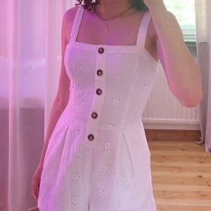 Vit playsuit från hollister - Playsuit med fickor och reglerbara band. Skulle säga att den är ganska liten i storleken, endast använd 1 gång:)