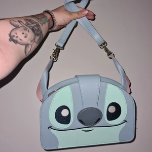 Loungefly stitch väska - Säljer denna heeeelt underbara väska!!! Endast använd på min bal och student! Helt felfri som ny! Tänkte mig 600kr men pris går att diskutera, från Loungefly. Kan mötas i Norrköping eller skickas mot frakt :)