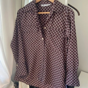 Skjorta från zara.   - Skjorta från zara, dålda knappar hela vägen ned, de två översta knapparna är synliga. Använd 1 gång. Färgen är burgundy och beiga mönster. 