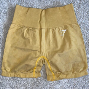 Gymshark vital seamless shorts S - Ett par gula shorts från Gymshark i modellen vital seamless i strl Small. Sitter superbra och är väldigt sköna. Jättetjockt midjeband som sitter riktigt bra och länge! Färgen är lite urtvättad så är inte lika ”chockgul” som den var innan, men fortfarande en väldigt fin gul färg 💛 
