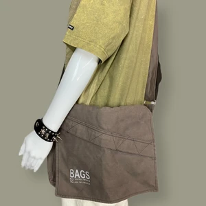 Axelremsväska  - Back to shcool 90sliknande axelremsväska i toppenskick, inget märke finns. Diskret dragkedja på framsidan. Ljusgrå text “Bags make you feel freedom so, feel the freedom”. Fri spårbar frakt. Mått: Höjd 27cm, Bredd 32.5cm & Djup 6.5cm. 