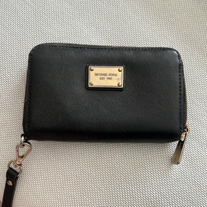 Plånbok från Michael Kors  - Svart plånbok från Michael kors i läder. Skavd på färgen på metall-loggan och dragkedjan annars i fint skick.