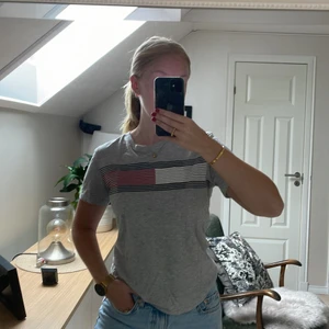 T-shirt Tommy Hilfiger - Säljer denna gråa Tommy Hilfiger t-shirt från Kids Brand Store. Är i storlek 164 men passar mig som vanligtvis har S. Säljer då den inte kommer till användning längre. Tröjan har inga defekter. Hör av er vid frågor!🤍