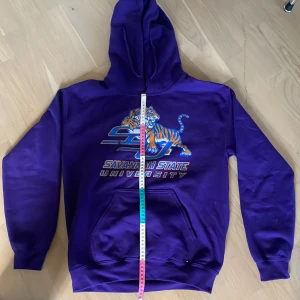 Vintage Lila Collage Hoodie - Snygg lila 90s hoodie med tryck. Trycket har fadeat lite, men det är fortfarande nice, 