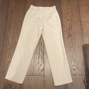 Kostymbyxor  - Beiga kostymbyxor från NA-KD, en liten fläck precis över ena bakfickan men man ser den knappt i verkligheten , därav priset. Storlek 38, 50kr+frakt 