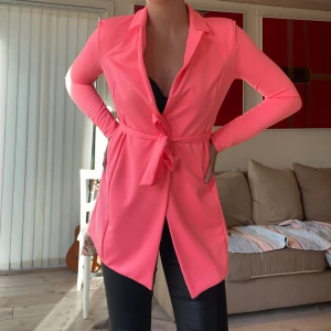 Blazer strl S - Neonrosa blazer från Nelly i storlek S. Så häftig färg speciellt på sommaren när man är brun. Snyggt till cykelbyxor, kjol och jeans! Använt endast en gång, i nyskick!💞👚
