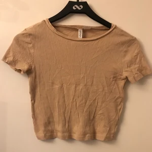 H&M divided beige T-shirt stl XS - Säljer denna beiga croppade tröjan! Den är använd ett fåtal gånger och är därför i okej skick! Hör av dig om du undrar något <3