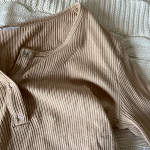 Tröja Beige  - Beige ribbad långärmad t-shirt från hm. Kortare modell, slutar ungefär i midjan. Alla knappar går att öppna och stänga. 💞