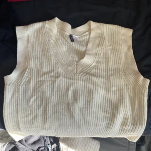 Vit stickad väst - stickad väst från H&M i storlek large. Väldigt bred och kort i modellen
