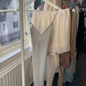 Klänning - Festlig, glittrig klänning i nyskick. Endast prövad då den inte kommit till användning, prislappen sitter kvar. Smickrande passform och öppen rygg med korsade tunna band. Kan skicka fler bilder i DM 🌸😊