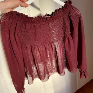 Vinröd vacker offshoulder topp (oanvänd) - Jag säljer nu en oanvänd vinröd off shoulder topp/tröja i XS från Gina tricot som aldrig kommit till användning. materialet är som ni ser väldigt luftigt och genomskinlig med lite puffärm. Fina detaljer som sagt, om ni vill ha fler bilder om hur den sitter på är det bara att skicka iväg ett meddelande!❤️