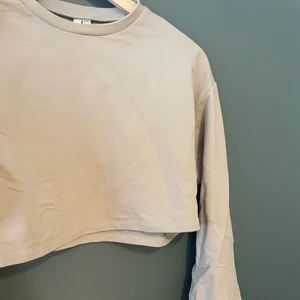 Croppad tröja med stora ärmar - En superfin beige tröja från Nelly. Knappt använd. Den är i XXS men skulle säga att den passar XS