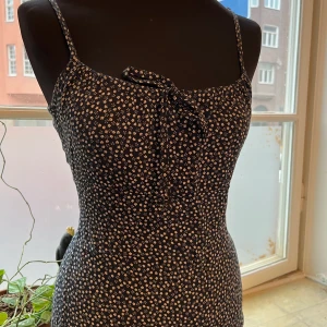 Kortklänning från brandy melville  - Mönstrad kortklänning från märket brandy melville i fint skick. Justerbar framsida och band. Dockan på bilden är en strl S.