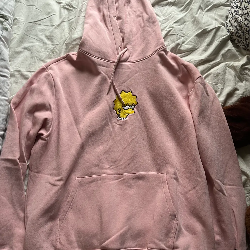 En mjuk rosa hoodie från H&M med broderat märke av karaktär från serien The Simpsons och broderad text ”NOT INTERESTED!” på höger ärm. Om du har några frågor så är det bara att kontakta! :). Hoodies.