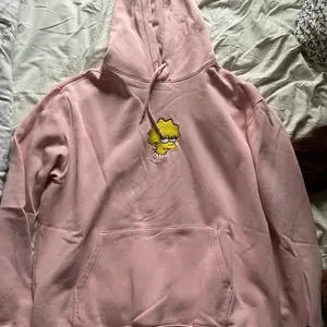 En mjuk rosa hoodie från H&M med broderat märke av karaktär från serien The Simpsons och broderad text ”NOT INTERESTED!” på höger ärm. Om du har några frågor så är det bara att kontakta! :)
