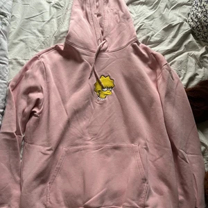 Rosa hoodie med broderat märke - En mjuk rosa hoodie från H&M med broderat märke av karaktär från serien The Simpsons och broderad text ”NOT INTERESTED!” på höger ärm. Om du har några frågor så är det bara att kontakta! :)
