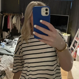 Randig tshirt  - Säljer en vit, blå randig T-shirt 