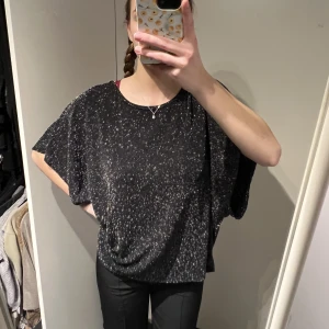 Glittlig tröja - Fin svart glittrig tröja i bra skick. Riktigt snyggt med kort kjol och höga klackar till!