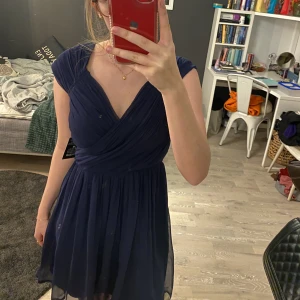 Klänning  - En mörkblå klänning från Nelly med lappen kvar. Klänningen slutar över knäna och är i strl 38. Säljer för 180kr