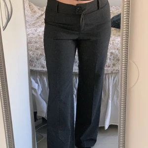 Lågmidjade kostymbyxor - Säljer dessa mörkgråa low waist kostymbyxor som är köpa på secondhand. Längden är bra på mig som är 170cm lång!