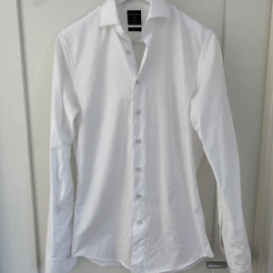 Vit skjorta - Superfräsch vit märkesskjorta. Passar perfekt till både kostym och jeans. Använd en gång. Slim fit. Strl 38 typ Medium. 