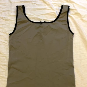 Gulligt linne  - Jättesött linne med rosett i väldigt tajt och stretchigt material, typ som en träningstopp. Står one size men skulle säga xs eller tajt s. Köpt vintage ❣️