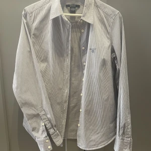 Gant skjorta, dam strl 42 - Gant-skjorta, blåvit smalrandig i mycket bra skick. 97%bomull 3% elasten.   Köpare står för frakt. 