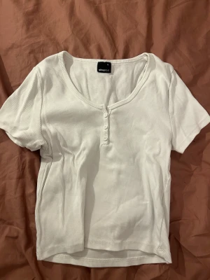 Vit topp - Vit topp med knappar från Gina Tricot. Använd 4-5 gånger. Säljer på grund av att jag inte använder topp längre. Orginalpris: 139kr.