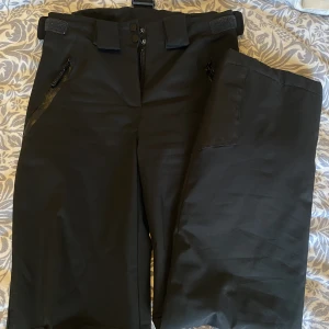 Skidbyxor - Säljer ett par lite tunnare skidbyxor/täckbyxor i strl XS. Sitter tight och passar bra i längden på mig som är 164cm. Finns även avtagbara hängslen till som inte syns på bilderna. Knappt använda och inga defekter. Justerbara i midjan. 