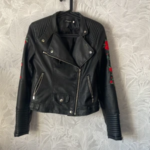 Läderjacka  - Superfin bekväm fejkläder jacka med broderade rosor på ärmarna. Passar xs-s. Riktiga fickor och mjuka bra dragkedjor❤️