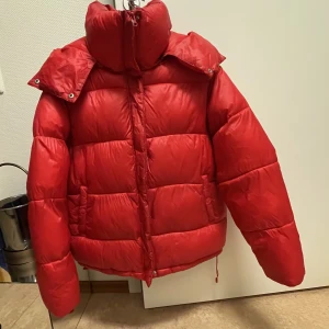 Röd pufferjacka - Väldigt varm pufferjacka från bikbok, nästintill oanvänd. Stark röd färg och lite glansig