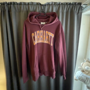 Carhartt hoodie - Svinsnygg carhartt hoodie i en härlig vinröd färg. Ägt hoodien länge men inte fått så mycket uppmärksamhet de senaste åren. Men trots de så är den i top skick😀pris inte ristat i sten!