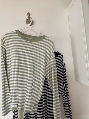 Randiga tröjor Monki  - Två randiga tröjor, en grön och en svart. Kan säljas för sig! Den svarta är väl använd med är i fint skick. Den gröna är inte lika använd men också i fint skick. Nypris 180 kr (styck) Mitt pris- 130 kr för båda, styckpris 75 kr. Passar xxs-s