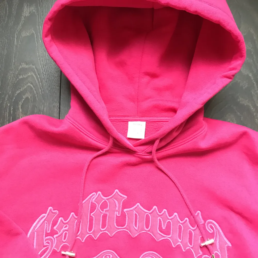 Oversized rosa hoodie med broderat tryck. Fleece-material på insidan och stor luva. Använd några gånger, bra skick :). Hoodies.