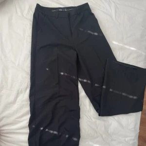 Baggy kostymbyxor - Använda fåtal gånger. Strl 34 men de är nästan för stora för mig som brukar ha strl 36. Byxorna passar upp till 38! Går att anpassa om man vill ha lågmidjat eller högmidjat’