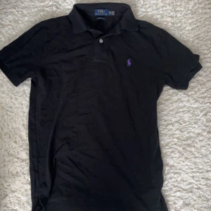 Ralph lauren Piké - Svart Polo Ralph lauren piké med lila märke vilket är ganska ovanligt. Säljer den eftersom den är för liten, strl är xs men funkar 100% som S