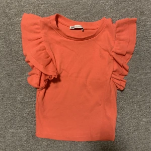 Volang topp zara - Supersöt zara topp med volang vid armarna. Nypris ca 149 kr. En somrig rosa/orange färg. Helt oanvänd.