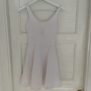 Vit klänning från H&M, storlek 32  - En vit fin klänning från H&M i storlek 32 Ops det är inte en fläck som visas på bilden utan den svarta lappen som syns igenom tyget  Postar men du står för fraktkostnad  Kan eventuellt mötas