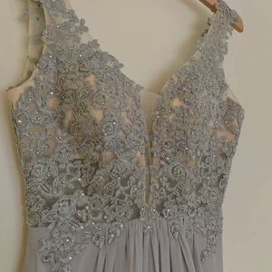 Balklänning - Säljer min gamla balklänning, superfin ljusgrå färg och sitter fint på. Liten på mig nu dock och kommer aldrig till användning, men kan passa bra till bal, bröllop eller annat event. Har även en inbyggd bh typ, alltså vadderad så behöver inte ha bh under vilket är bra då tyget är lite mesh aktigt och genomskinligt ish. Köptes för 2000kr.