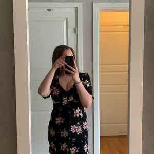 Blommig sommarklänning  - En fin blommig sommarklänning som passa till allt.    Den är V-ringad & är knappar hela vägen ner. Klänningen är köpt från Bershka. Då storlekarna där ifrån brukar vara mindre än våra vi har i Sverige. Skulle säga att den egentligen är S/M och inte L. 