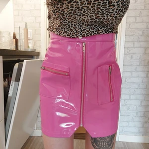 Rosa kjol - Rosa kjol i lack material . Endast provad så den är nyskick.  Storlek S 