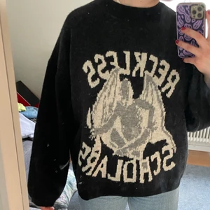  svart ulltröja med tryck - en svart ull tröja med en demon på, med texten ”Reckless  Scholars ” på framsidan enbart. Men den är tyvärr fake så tar såklart inte lika mycket för den som än äkta