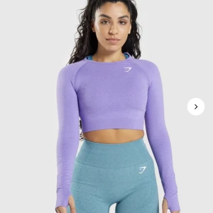 Gymshark croppad träningströja - Jättefin och bekväm träningströja från Gymshark. OBS. Tröjan är slut på hemsidan så fick bli en likadan fast i ljusare lila på bilden! 💜swipe för att se riktig färg