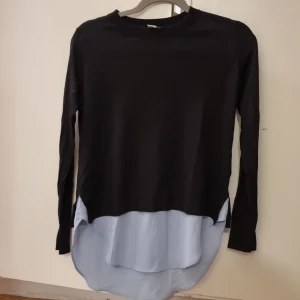 Svartblus med skjortdetalj - Svartblus som ser ut som över en skjorta men de är endast skjortdetalj vid nedre delen av blusen använt nån ggn 