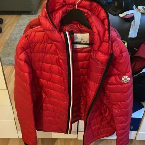 Moncler jacka röd herr  - Säljer en moncler jacka som knappt är använd. Inga hål eller defekter. Köpt för 10500kr. Kvitto finns samt påse. Pris kan diskuteras vid snabb affär