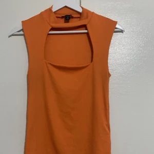 Orange topp akuten vid brösten - Fin orange topp. Perfekt för fester osv om man vill sticka lite ut! Storlek M men är rätt tight så passar S också!🫶BUDA🫶🫶